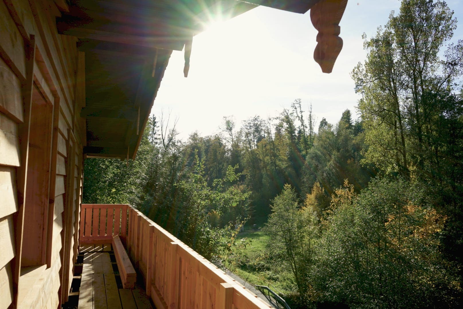 Tief stehende Sonne über dem langen Holzbalkon der Hütte