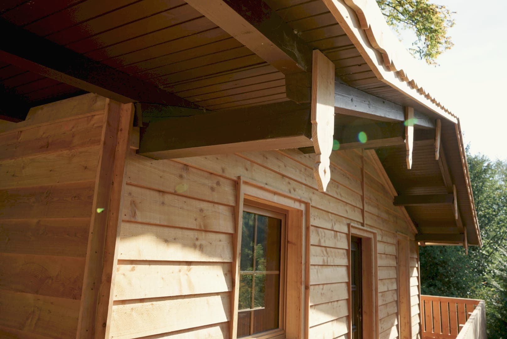 Holzfassade mit Fenster und Giebel der Hütte im Sonnenlicht