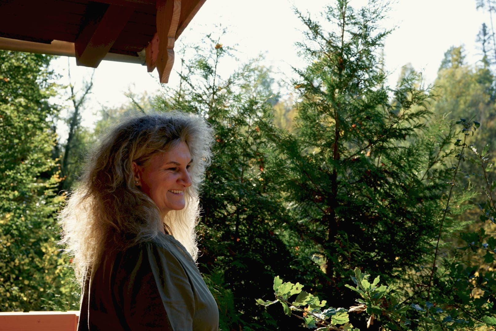 Bianca Thoma lächelnd auf dem Balkon der WALDRAUM-Hütte